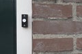 Black and white doorbell at the door of a living house