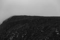 Black and white dramatic shot of the top of a mountain surrounded by the mist with copy space Royalty Free Stock Photo