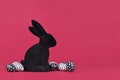 Black and white easter eggs with hearts and stripes next to bunny figure on pink background Royalty Free Stock Photo