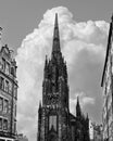 Black and white Edinburgh skyline, the Hub towering gothic spire aligns with rising cumulus clouds Royalty Free Stock Photo