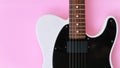 Black and white electric guitar on a pink background. Royalty Free Stock Photo