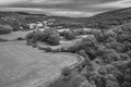 Black and white Epic aerial flying drone landscape image towards Crimpiau from above Llynau Mymber during Autumn sunset with
