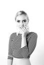 Black and white expressive portrait of a young stylish woman wearing stripes in the studio