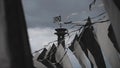 Black and white flags sway on wind in summer day. Cloudness sky before heavy rain. Column with flag