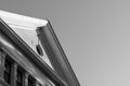 Black and white of gabled peak roof with oculus window and sliver moon in background.