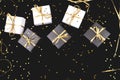 Black and white gift boxes with gold ribbon on shine background.