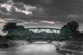 Black and white motion blurred train passing over metallic railway bridge at sunset Royalty Free Stock Photo