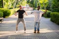 Black guy and white guy have fun and dance on the street in the Park. Interracial friendship
