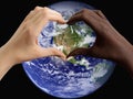 Black and white hands in the shape of a heart on the background of the planet Earth, USA Royalty Free Stock Photo