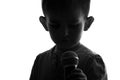 Black and white head silhouette of a small unrecognizable boy with a microphone for singing in the hands on white isolated backgro Royalty Free Stock Photo