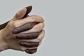 Black-and-white human hands in a joint handshake on a gray isolated background, gathered into a fist. The concept of combating Royalty Free Stock Photo