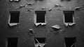 A black and white image of an abandoned building with broken windows and cracked walls Royalty Free Stock Photo