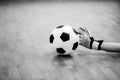 Black and white image of ball in hands of futsal goalkeeper on wooden futsal floor Royalty Free Stock Photo