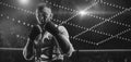 Black and white image of a bearded man in a white shirt and suspenders in the ring. The concept of fist underground fights