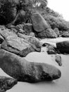 Black and white image of big rocks and cliffs on the beach of ocean lagoon at tropical island