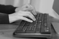 Black and white image of a business hands working and typing on laptop keyboard in office Royalty Free Stock Photo