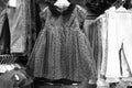 Black and White image of Children clothes hanging on hangers in the shop. Colourful kid blouses and shirt hanging on the cloth