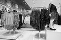 Black and White image of Children clothes hanging on hangers in the shop. Colourful kid blouses and shirt hanging on the cloth