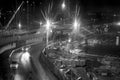 Black and white image of construction site with bright lights