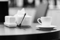 Black and white image of a cup of coffee tea on the wooden round table in modern cafe restaurant and blurred background. Royalty Free Stock Photo