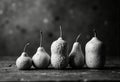 Black and white image of five pears arranged in a row on a textured surface Royalty Free Stock Photo