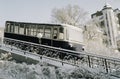A black and white image of a funicular tram going down a mountain in winter. Royalty Free Stock Photo