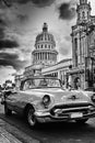 Black and white image of Havana street with vintage car and Capitol building Royalty Free Stock Photo