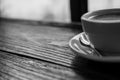 Black and white image of hot coffee cup on vintage wooden table Royalty Free Stock Photo