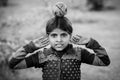 A black and white image with an indian girl with a fruit on her head