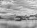 Black and white image of lake Wanaka with boats and mountains on the background