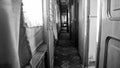 Black and white image of long narrow corridor in vintage train car Royalty Free Stock Photo