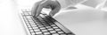 Black and white image of male hand using computer keyboard Royalty Free Stock Photo