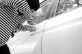 Black and white image of the man robber with a balaclava on his head trying to break into the car/Criminal and car Royalty Free Stock Photo