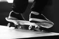 A black-white image of a man`s feet, doing a slide on a skateboard on a ramp Royalty Free Stock Photo