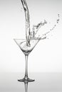 Black and white image of Martini glass with liquid pouring into it and splashing Royalty Free Stock Photo