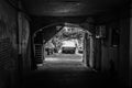 Black and white image of the narrow archway to the courtyard.