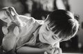 Black and white image new normal lifestyle, Candid shot kid lying on floor playing with dog toy, Happy Child boy lying on carpet