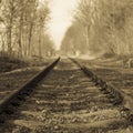 Black and white image of an old train line in a straight line, losing itself on the horizon Royalty Free Stock Photo