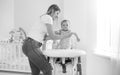 Black and white image of oyung mother seating her baby son in highchair for feeding Royalty Free Stock Photo