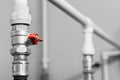 Black and white image of plumbing valve with red faucet on the plastic water pipe of plumbing system. Close-up Royalty Free Stock Photo