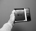 Black and white image Point of view male hand holding showing unboxed Apple TV