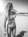 Black and white image of sexy young woman in bikini posing on the sandy sea beach at bright sunny day. Girl relaxing and Royalty Free Stock Photo