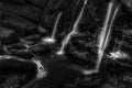 Black and white image of streams of water on rocks