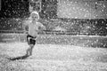 Happy Toddler Playing in the Sprinkler in the Yard