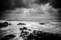 Black and white image wave hitting the coastline with dramatic cloud