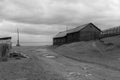 Black and white image of a wooden house on the shore of Lake Baikal in the village of Big Cats