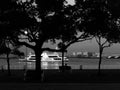 Black and white image of Yamashita Park at dusk. Silhouette of trees and people sitting on a bench enjoying the night view of the Royalty Free Stock Photo