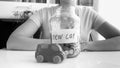 Black and white image of young woman saving money for purchasing new car