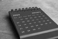 Black and white January 2024 desk calendar on wooden desk. New month concept Royalty Free Stock Photo