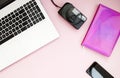 Black and white laptop keyboard, film camera, phone, pink notepad on a pink background. Copy space. Flat lay. Top view Royalty Free Stock Photo